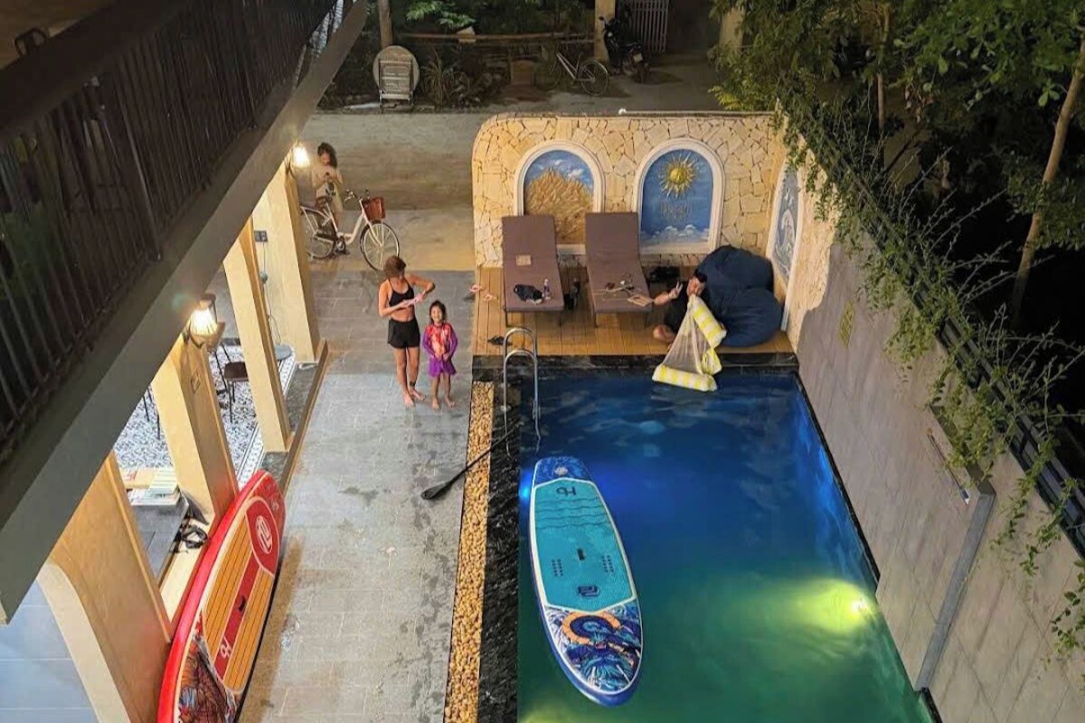 Una piscina interior amb un trampolí, gandules i un petit vaixell.