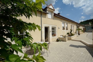 Un bâtiment avec une entrée carrelée, une porte et une fenêtre avec des volets.