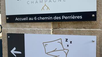 Dos carteles: uno para 'Marc Hennequière Champagne' y otro para 'Chambres Chez le Vigneron'.