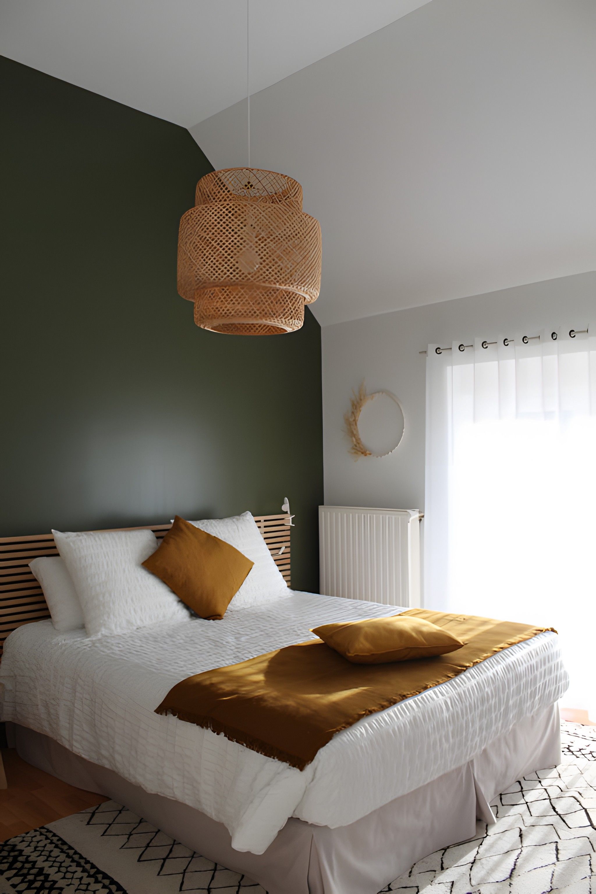 Un dormitorio con cama, lámpara colgante, radiador y ventana con cortinas.