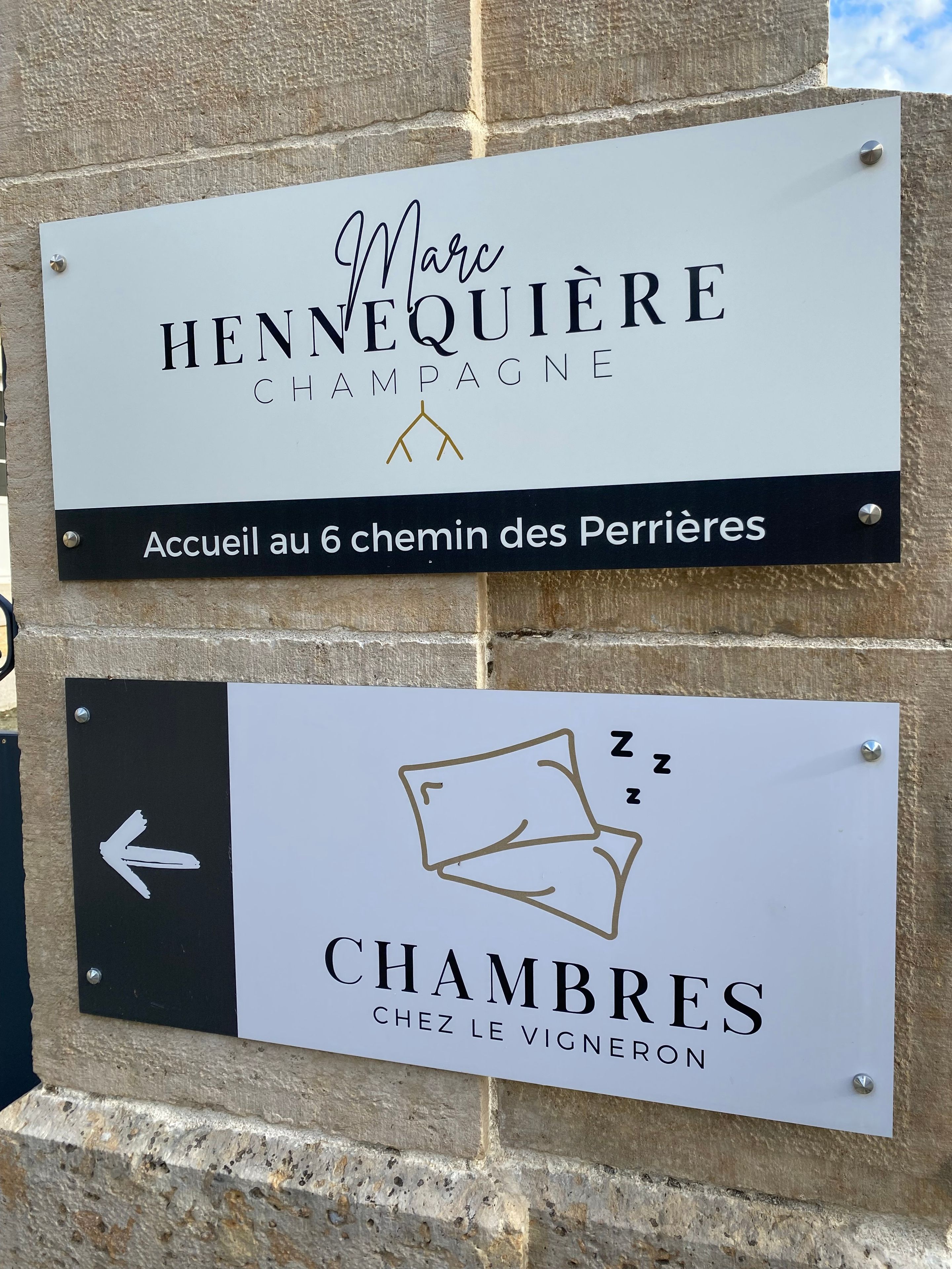 Deux panneaux : un pour « Marc Hennequière Champagne » et un autre pour « Chambres Chez le Vigneron ».