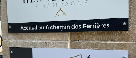Dos carteles: uno para 'Marc Hennequière Champagne' y otro para 'Chambres Chez le Vigneron'.