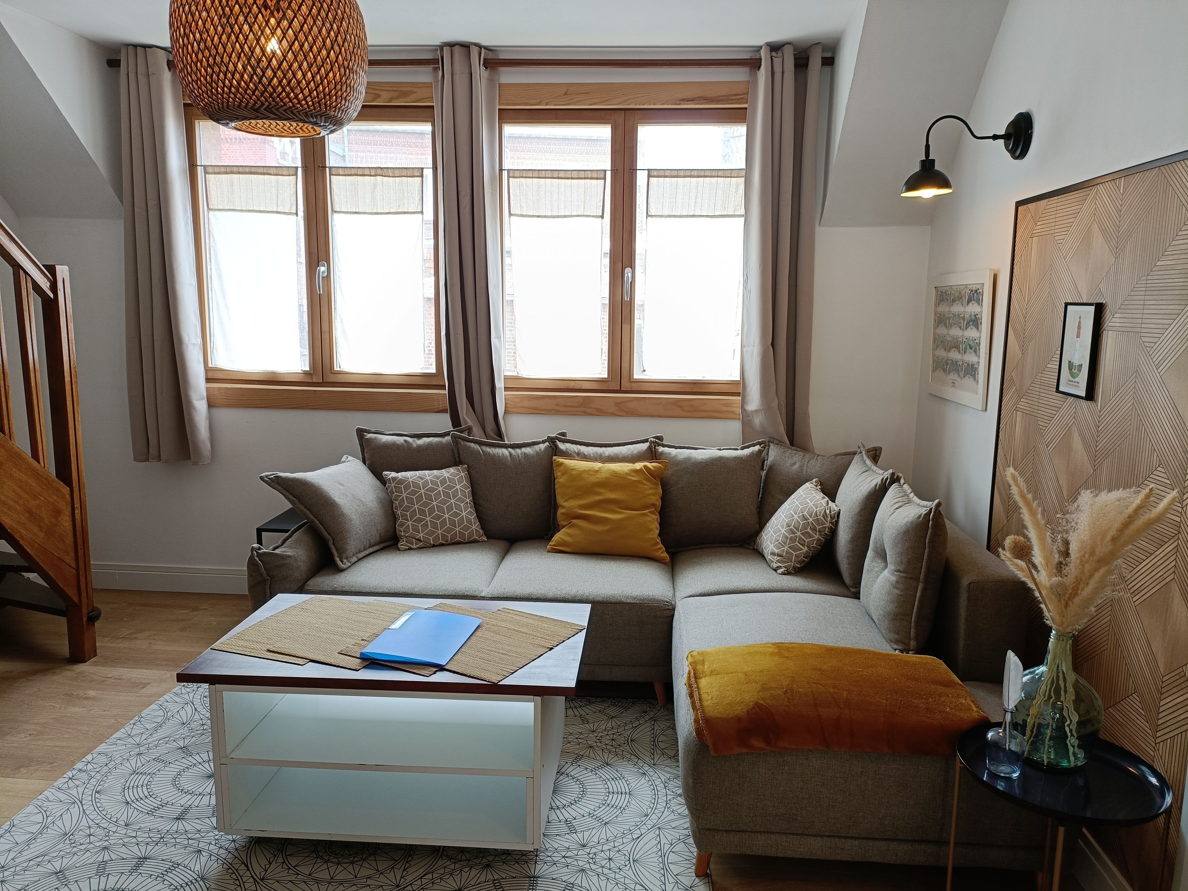A modern living room with a sectional sofa, a coffee table, and a patterned rug.