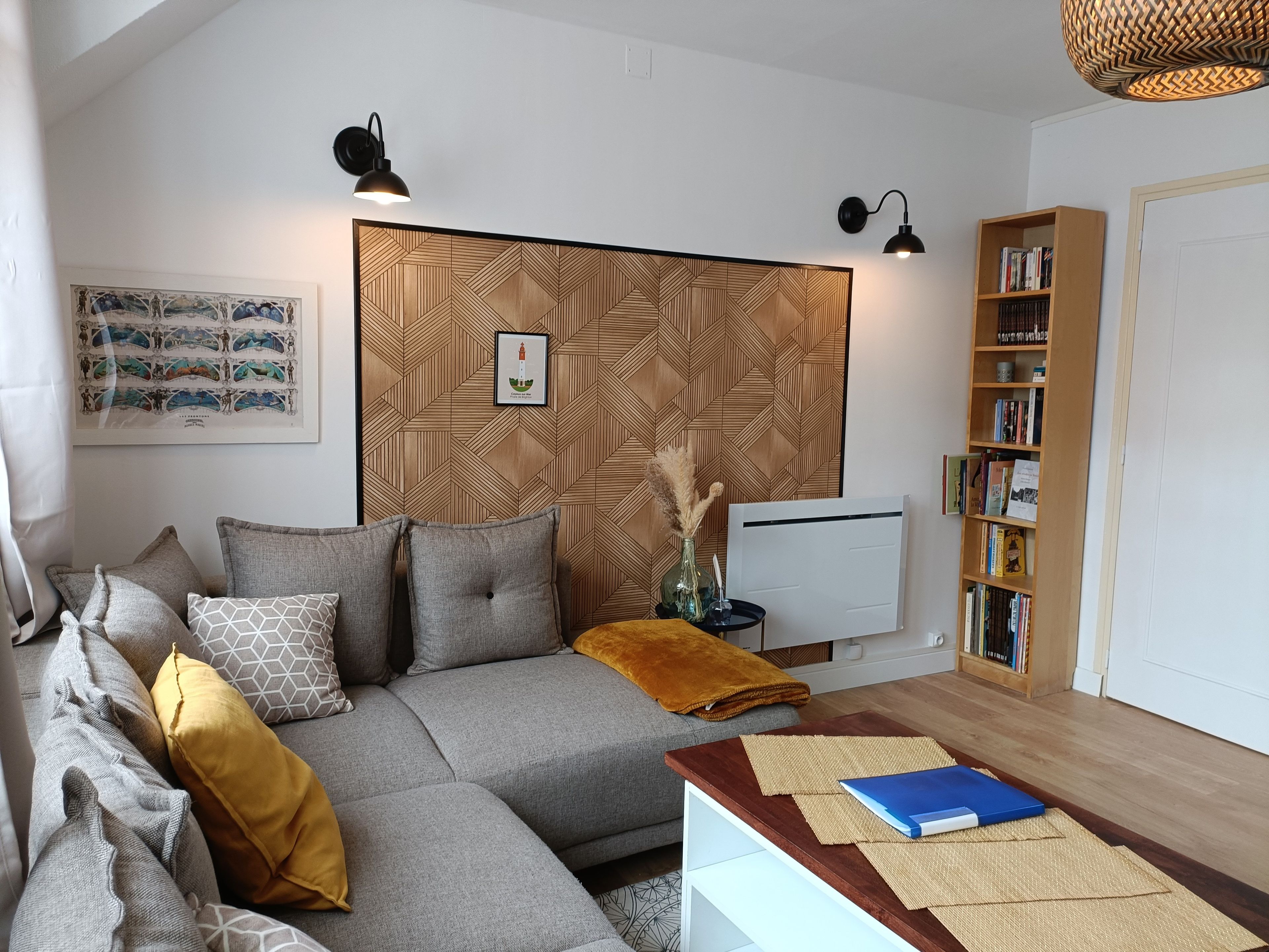 En moderne stue med en hjørnesofa, et sofabord, en bogreol og en tapetvæg.