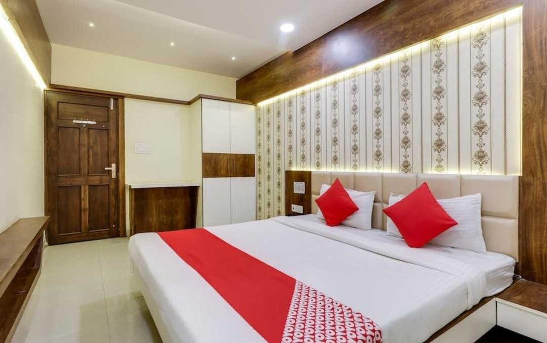 A hotel room with a bed, a wardrobe, and a nightstand.