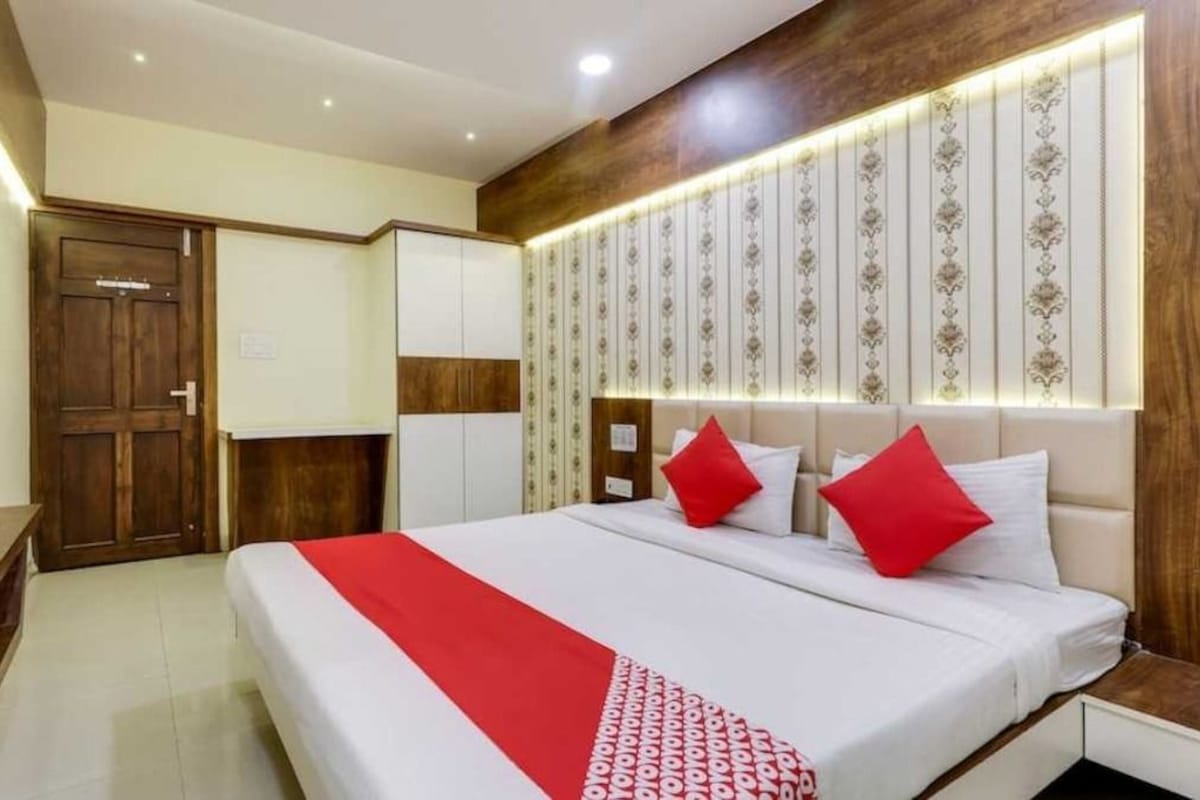 A hotel room with a bed, a wardrobe, and a nightstand.