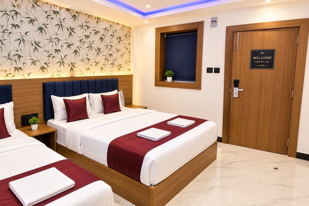 A hotel room with two beds, a wooden headboard, a welcome sign, and a wall with a bamboo leaf pattern.