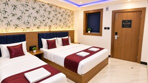 A hotel room with two beds, a wooden headboard, a welcome sign, and a wall with a bamboo leaf pattern. - Collection O Bandra Terminus (Mumbai)