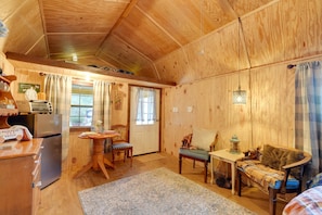 Ein gemütliches Blockhaus-Interieur mit Essbereich, Küche und einer Sitzecke mit Kamin.