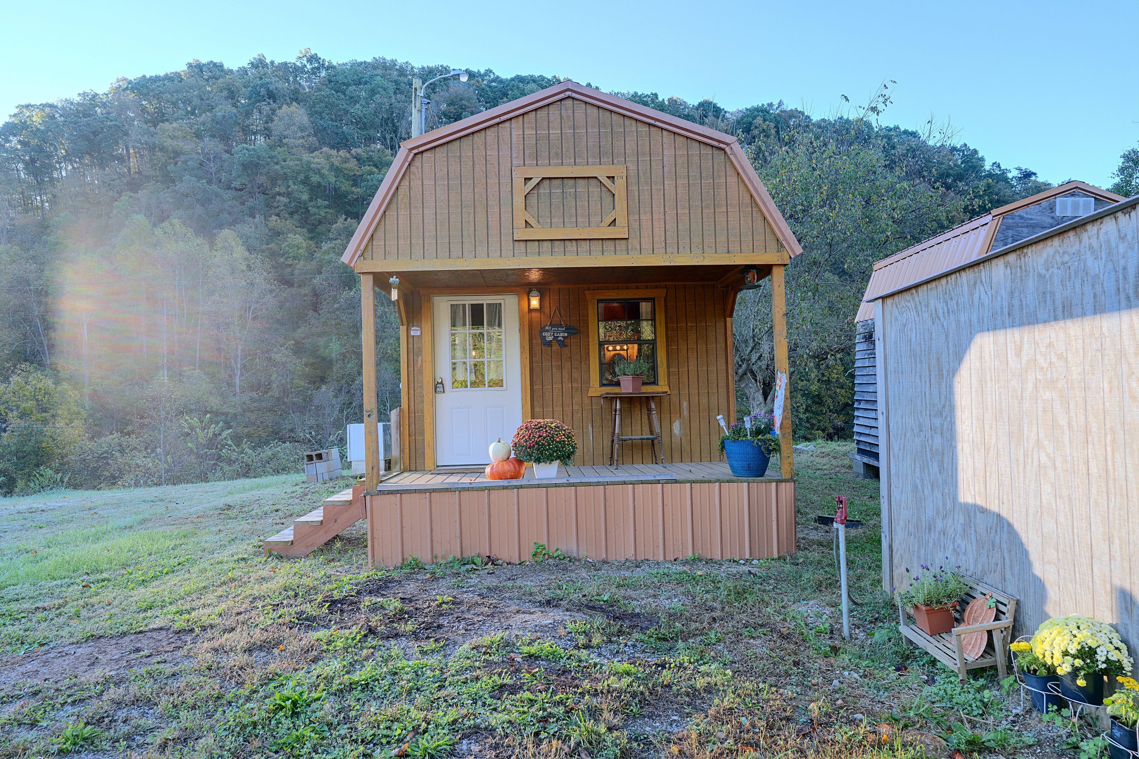 Uma cabana de madeira com varanda, porta e janela.