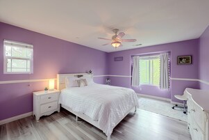 Un dormitorio con cama, mesita de noche, cómoda y ventilador de techo.