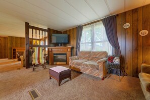 Una sala de estar acogedora con chimenea, televisor y un sofá cómodo.