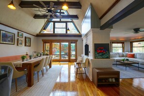 A spacious living area with a fireplace, dining table, and seating.