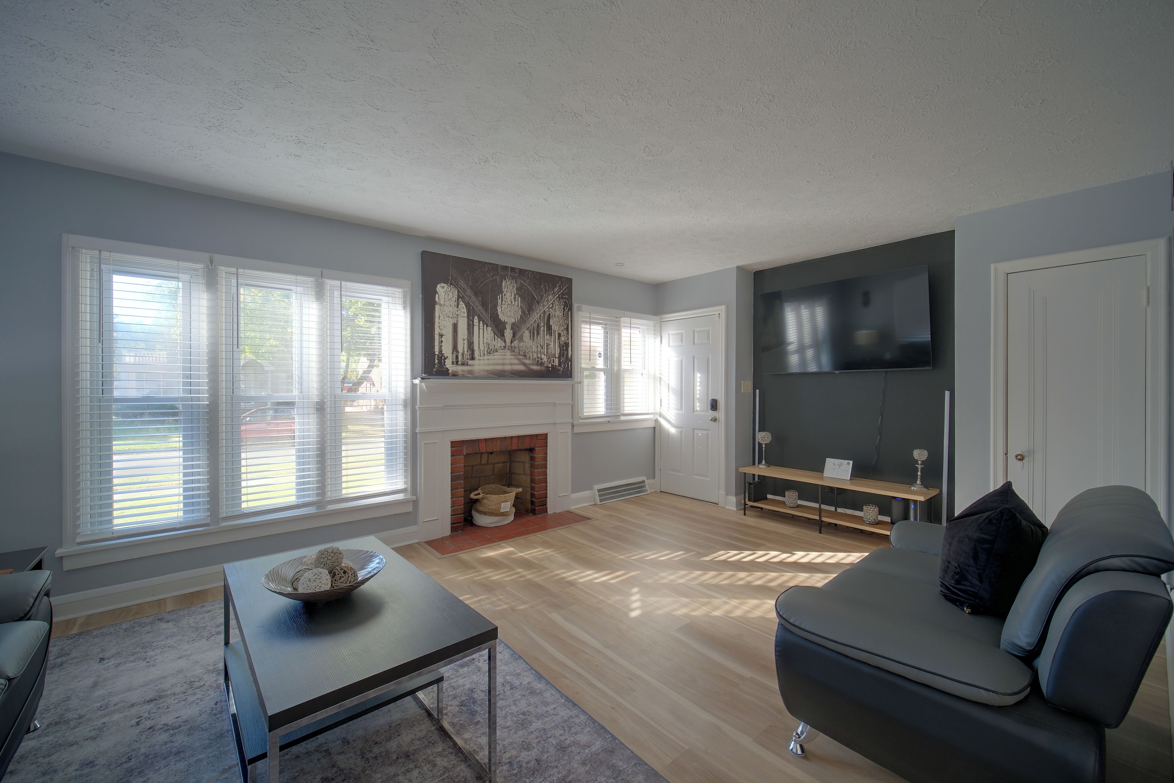 Una sala de estar moderna con chimenea, un televisor de pantalla plana y un sofá.