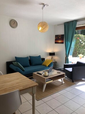 A living room with a sofa, coffee table, and a lamp. - Apartment 'Cosy Entre Lac Et Montagnes' with Private Terrace (Thônes)