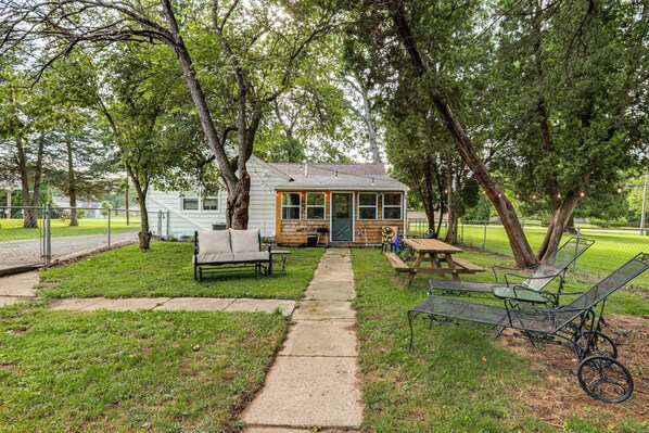 A rustic cabin with a porch, a picnic table, and outdoor seating.