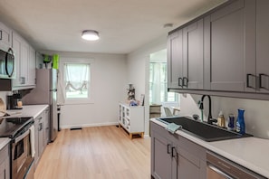 A modern kitchen with stainless steel appliances, a built-in oven, and a large sink.