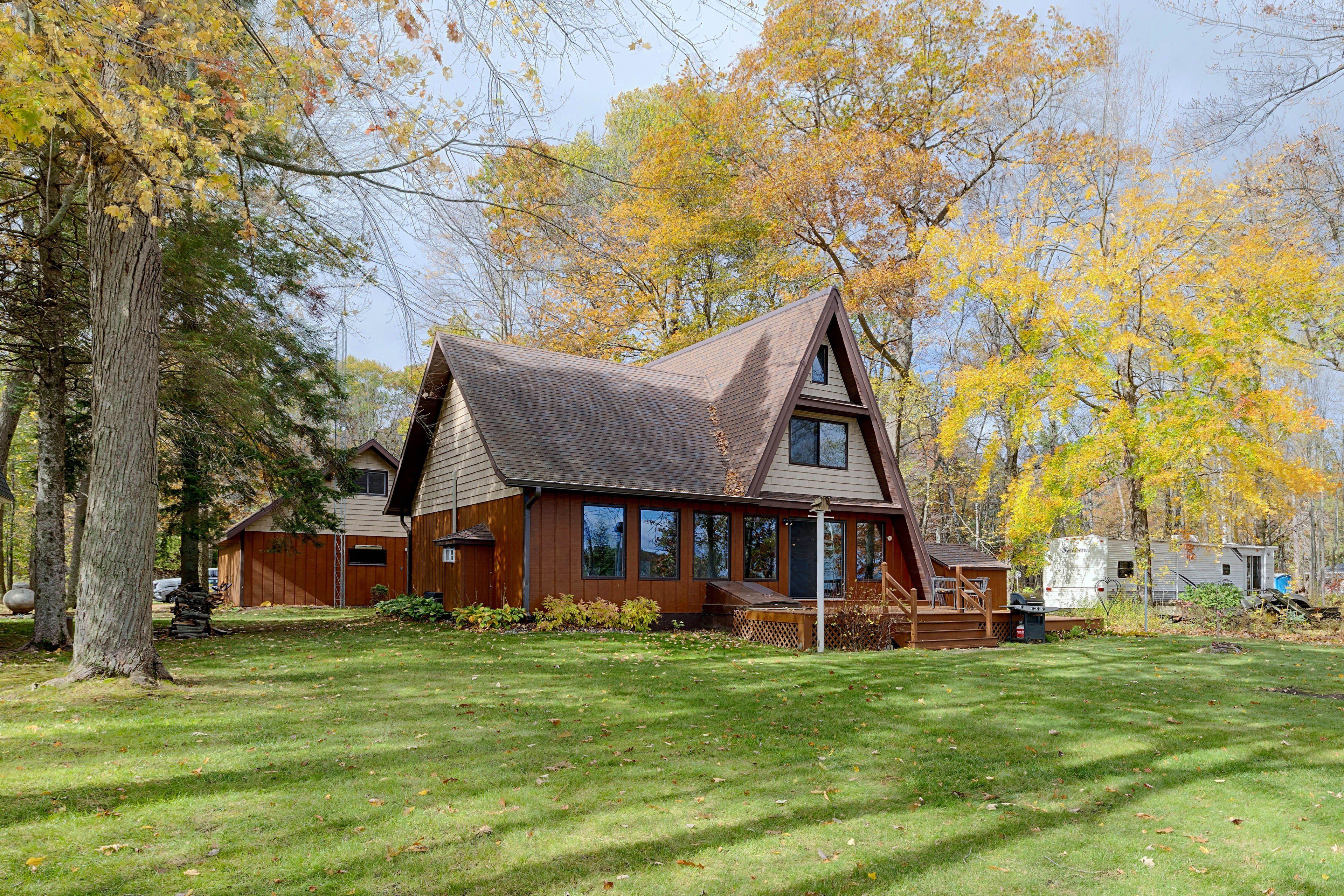 A cabin with a sloped roof, large windows, and a deck.
