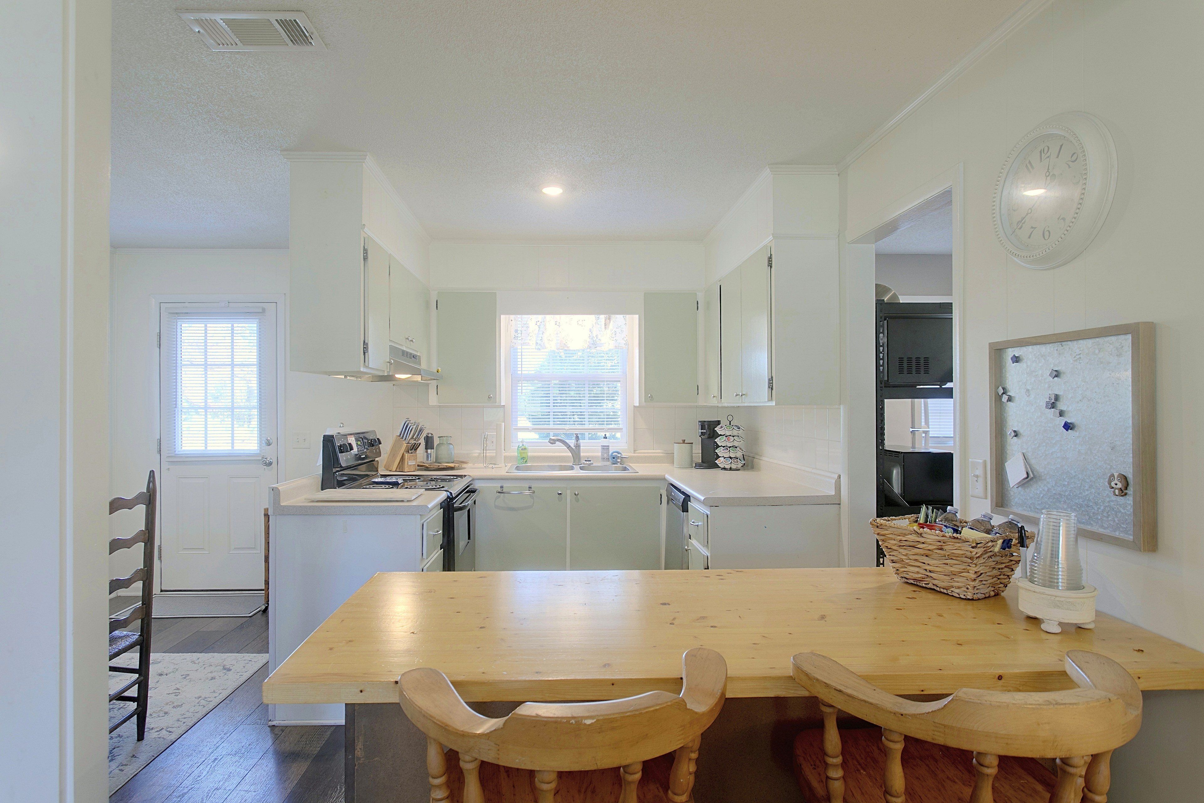 A kitchen with a wooden table and chairs, a sink, and cabinets.