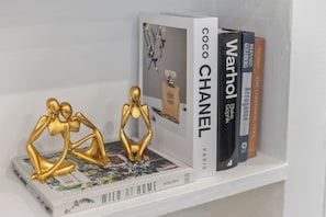 A bookshelf with books and decorative items. - Bright & Stylish London Studio | Full Kitchen | Near Hyde Park (London)