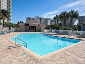 A rectangular swimming pool with a tiled deck, surrounded by lounge chairs and a white fence. - Seascape Golf Villa Unit #33D | Fairway Views + Resort Amenities (Miramar Beach)
