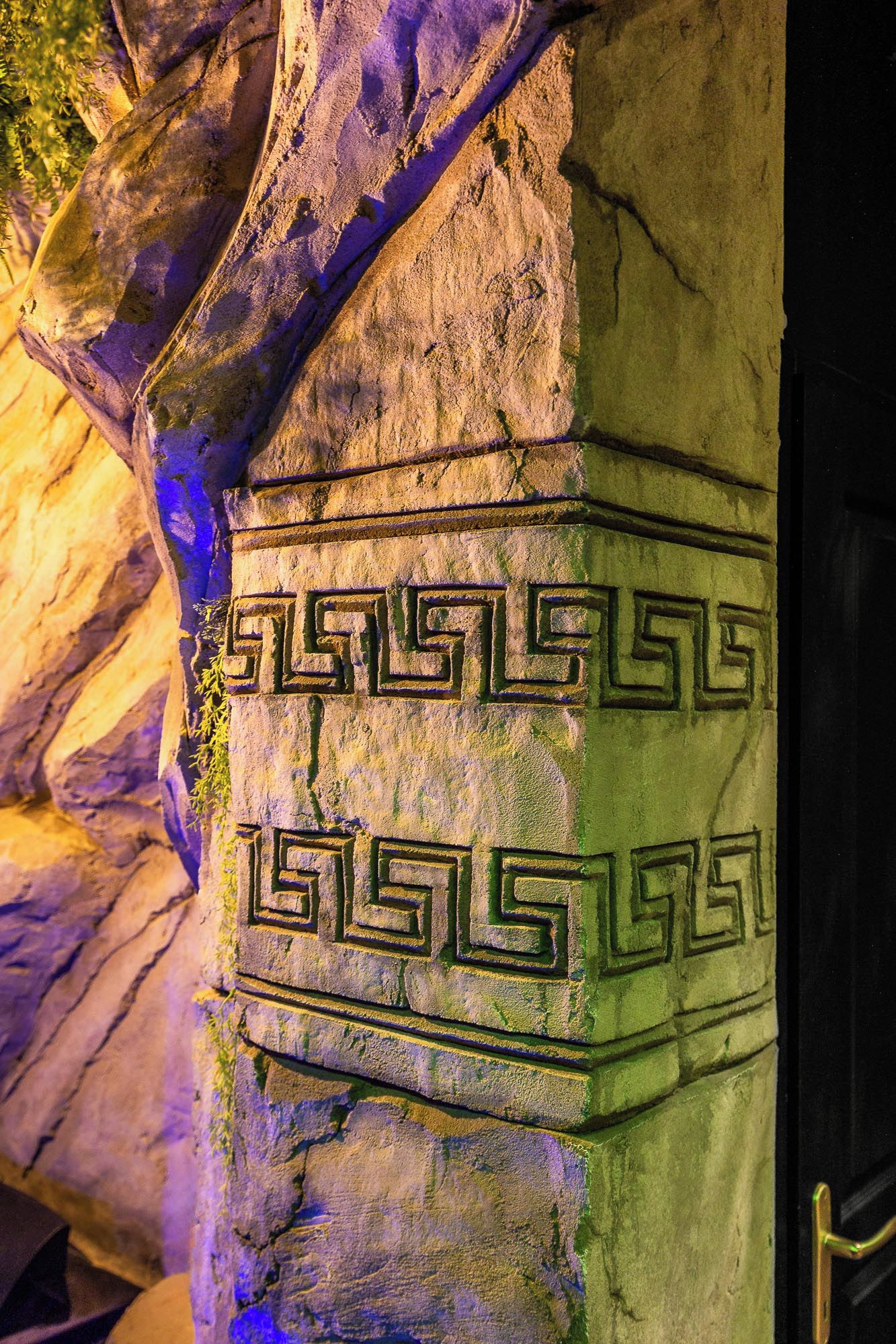 Un pilier de pierre orné de motifs grecs anciens en forme de méandre.