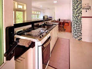 Une cuisine équipée d’une cuisinière, d’un four et d’un coin repas avec une table et des chaises.
