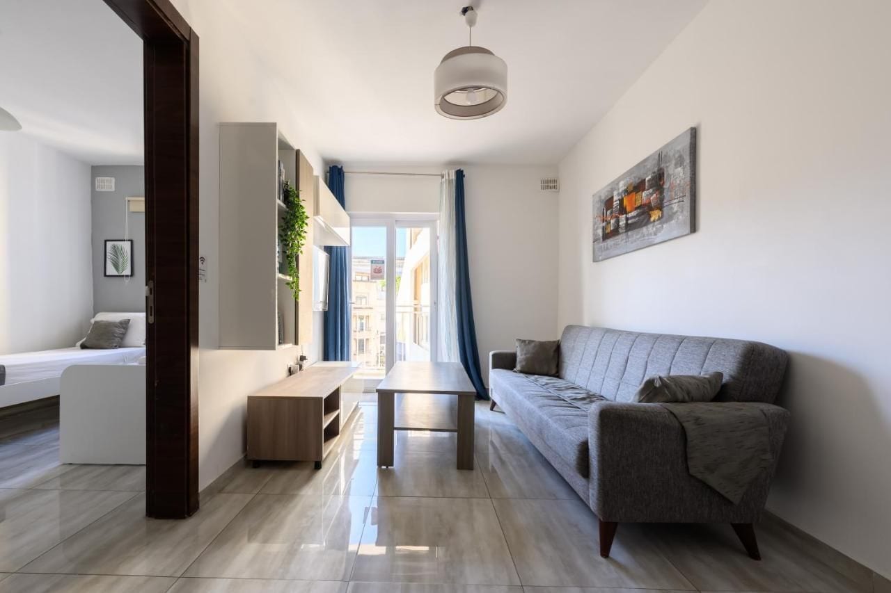 Un soggiorno moderno con un divano, un tavolino e una lampada a sospensione.