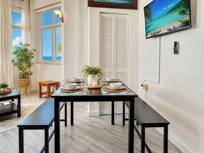 Un comedor con una mesa larga, platos blancos y una vela.