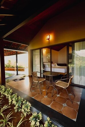 A modern interior with a dining area, a bed, and a view of the outdoors.