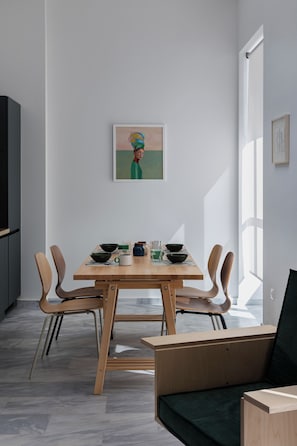 A modern dining area with a wooden table, chairs, and a minimalist decor. - Art Space Residencies Α1 (Athina)