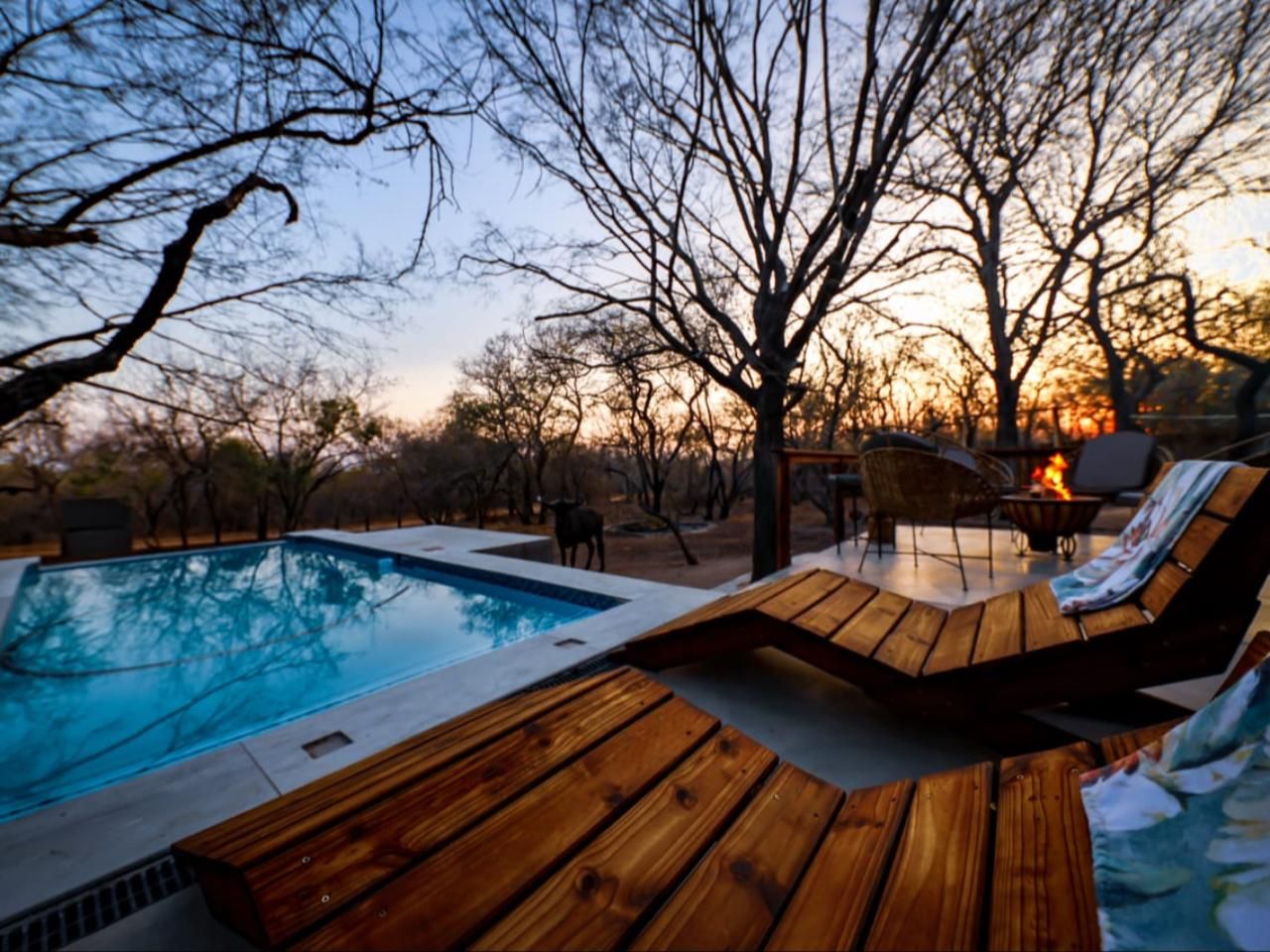 A pool area with wooden deck seating and a fire feature.