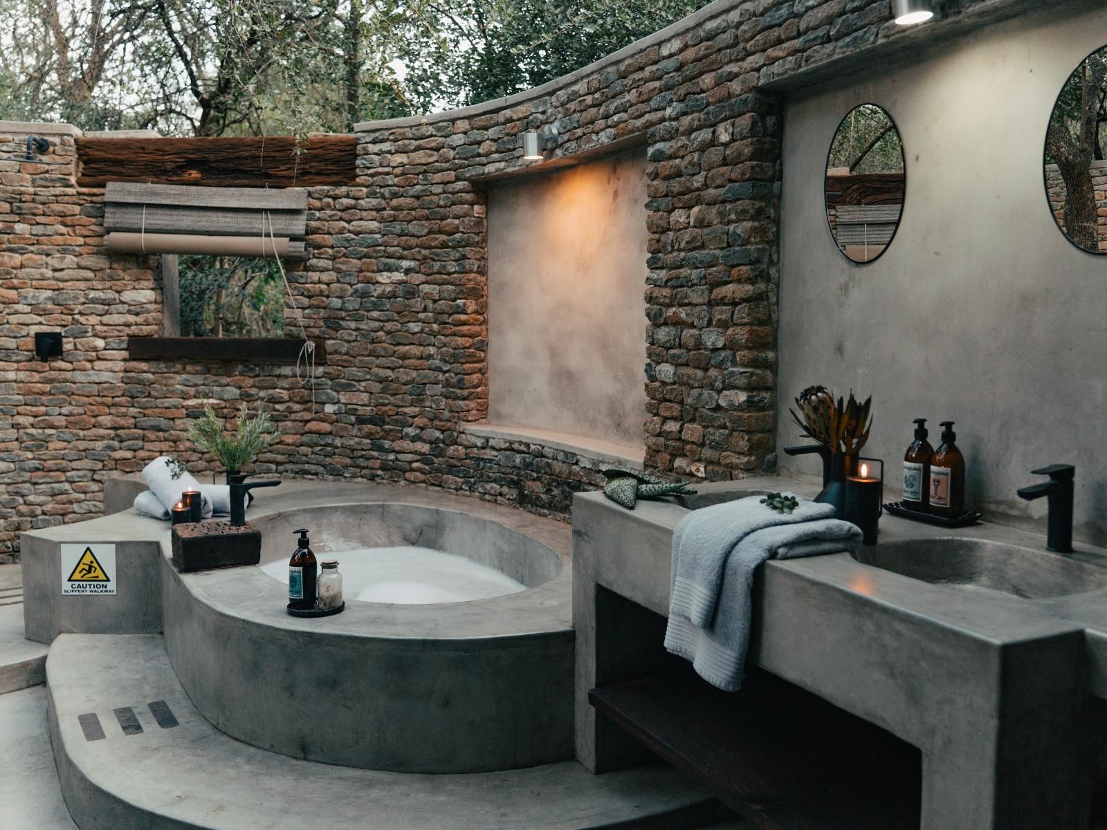 A spa area with a hot tub, stone walls, and a window.