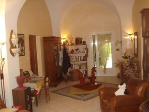 Una sala de estar acogedora con chimenea, una estantería y un comedor.