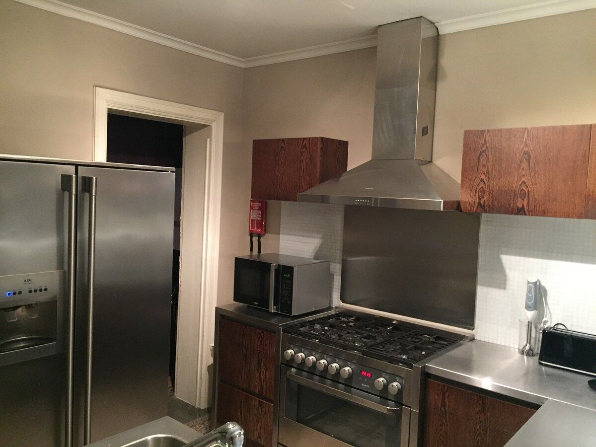 A kitchen with stainless steel appliances, including a refrigerator, microwave, stove, and oven.