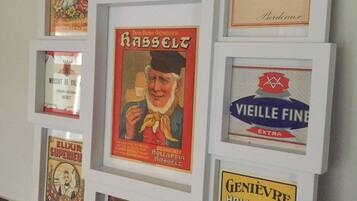 Een muur met meerdere lijstwerken van oude advertenties.