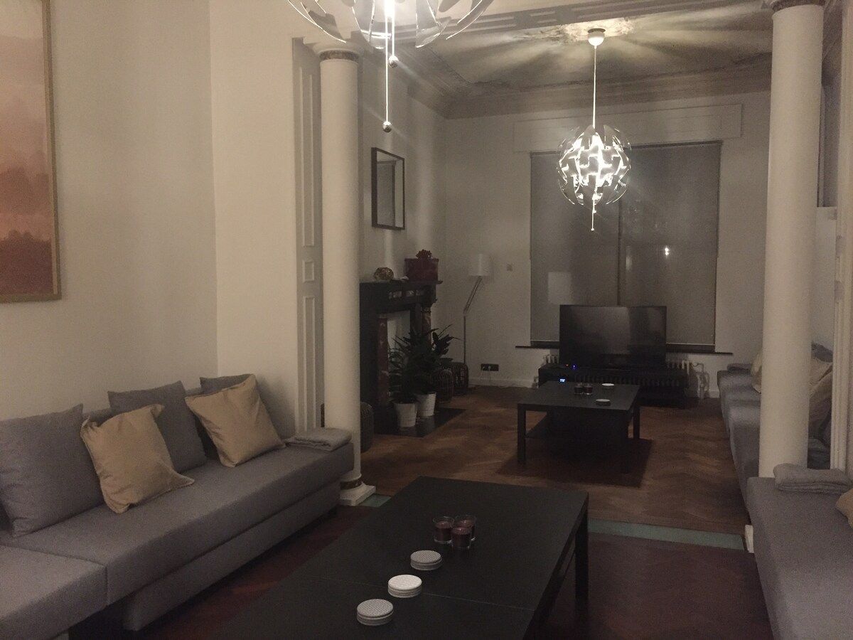 A living room with a sofa, a coffee table, and a television.