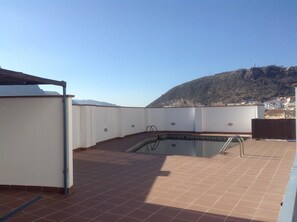 Una piscina en la azotea con una vista despejada de una montaña al fondo.