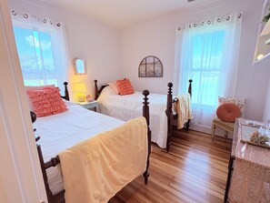 A bedroom with two beds, wooden flooring, and a window with a view. - 3 bedroom farmhouse located in the beautiful Shenandoah valley, just off I -81 (Staunton)