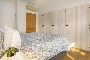 Ein Schlafzimmer mit einem Bett, einem Holzschrank und einer Tür.