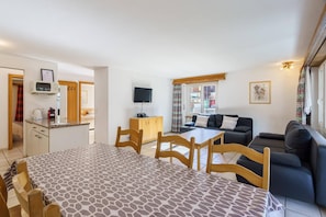 A compact living space with a dining area, kitchenette, and seating area. - Comfortable 2 Bedroom Apartment with Mountain Views Haus Alfa (Saas Fee)
