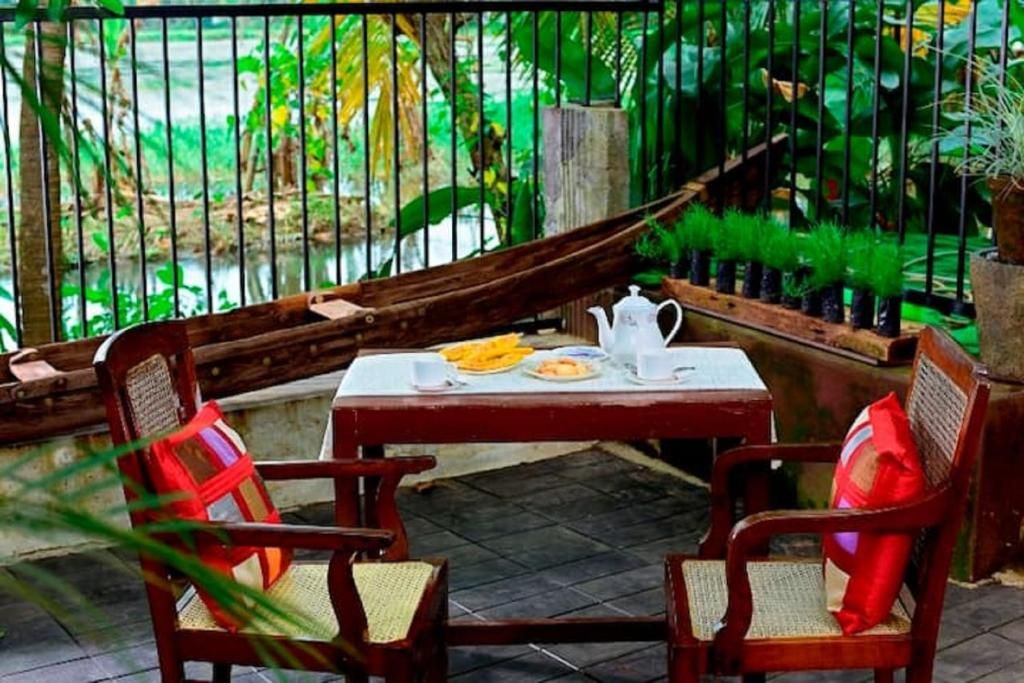 A wooden table with chairs, a hammock, and potted plants in a garden setting.