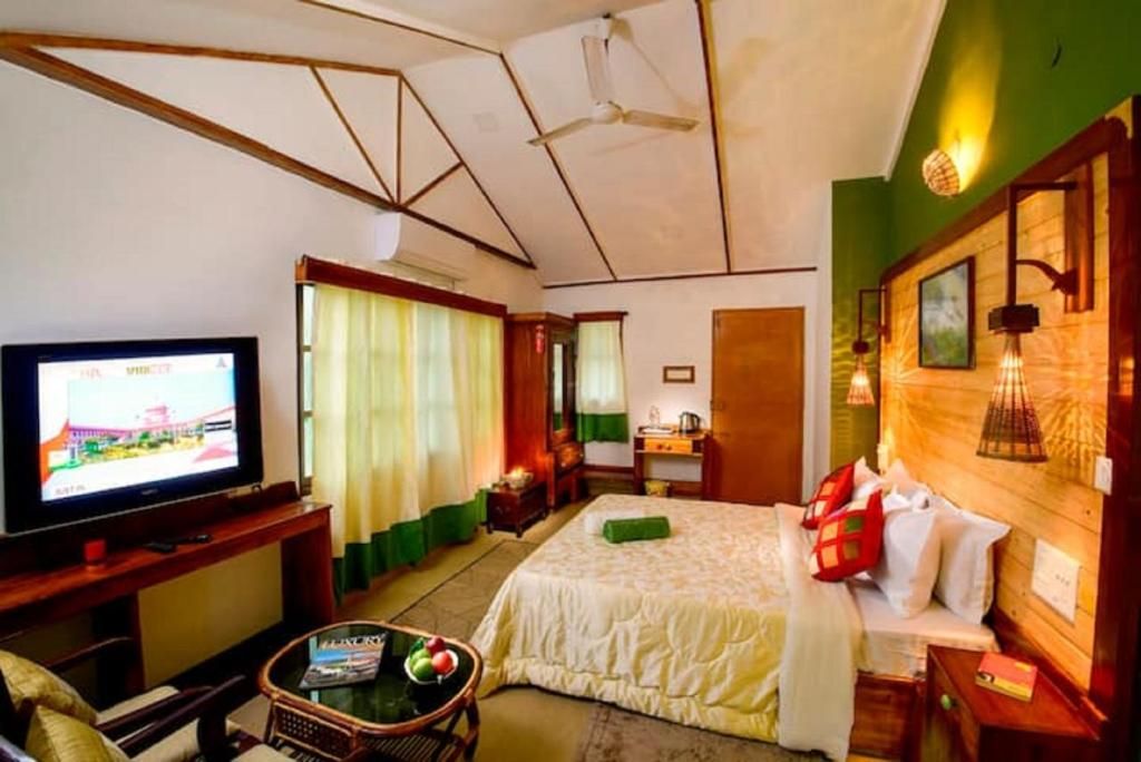 Een hotelkamer met een bed, een televisie, een bureau en een stoel.