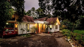 A two-story house with a gravel driveway and a red car parked in front. - Riverdale Homestay Kumarakom by LexStays (Arpookara)