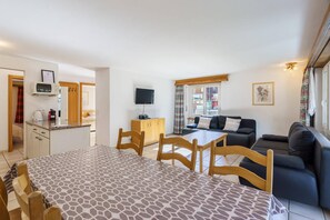 A compact living space with a dining area, kitchenette, and seating area. - Comfortable 2 Bedroom Apartment with Mountain Views Haus Alfa (Saas Fee)