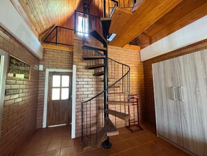 A spiral staircase with a metal railing, a wooden door, and a wardrobe with a light wood finish. - Ahas Pokuna Holiday Resort (Barandana)