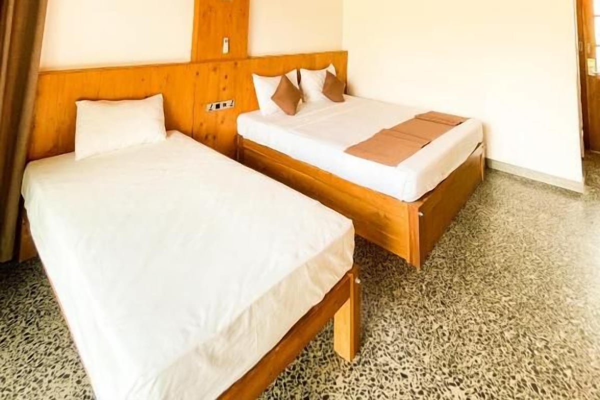 Habitación con dos camas, techo de madera y ventilador de techo.