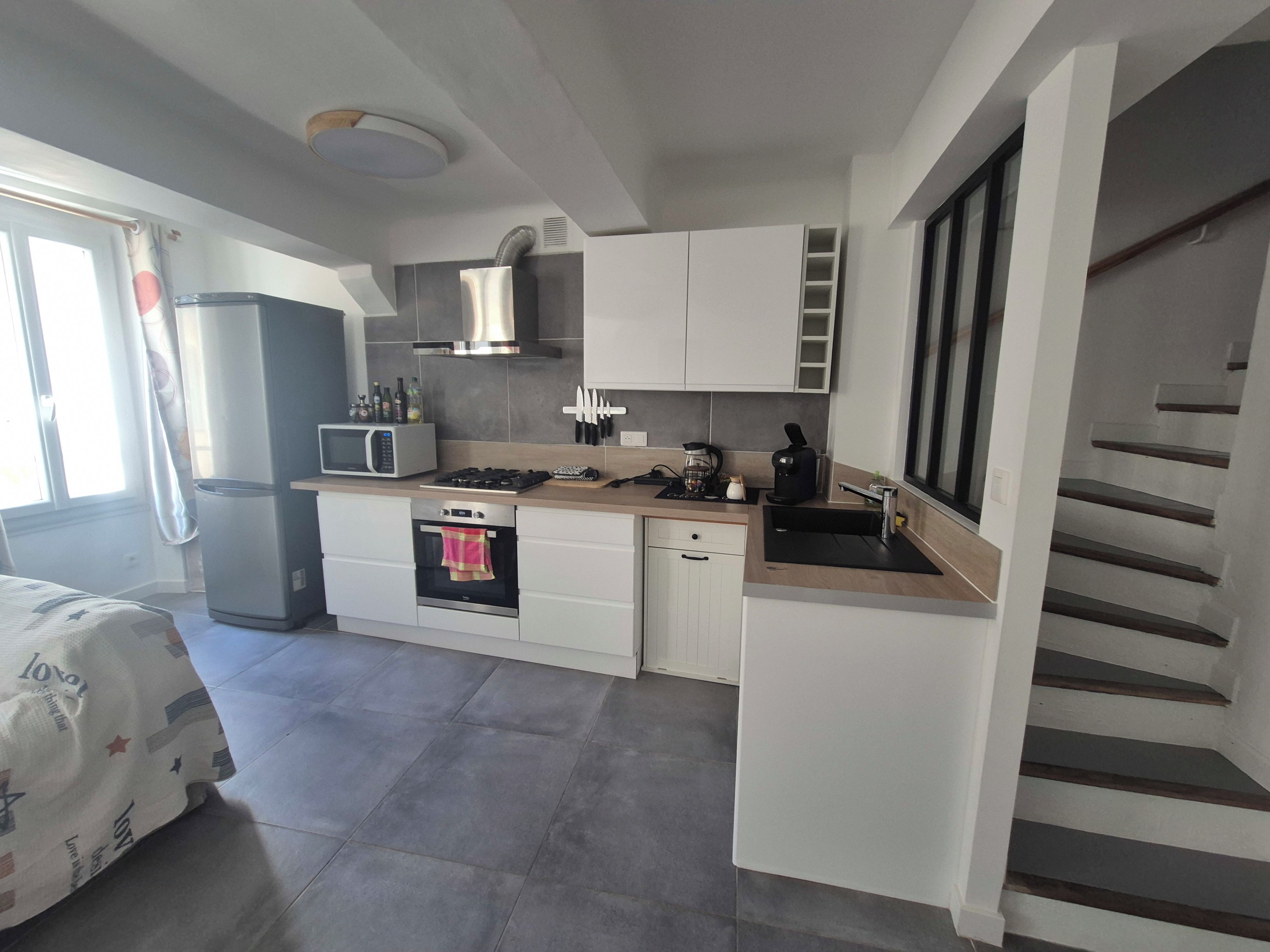 Een kleine keuken met een magnetron, fornuis, oven en spoelbak.