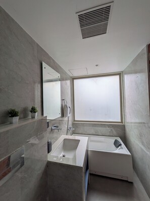 A modern bathroom with a large window, a bathtub, and a sink. - Hotel Vifa Retreat (Lucknow)
