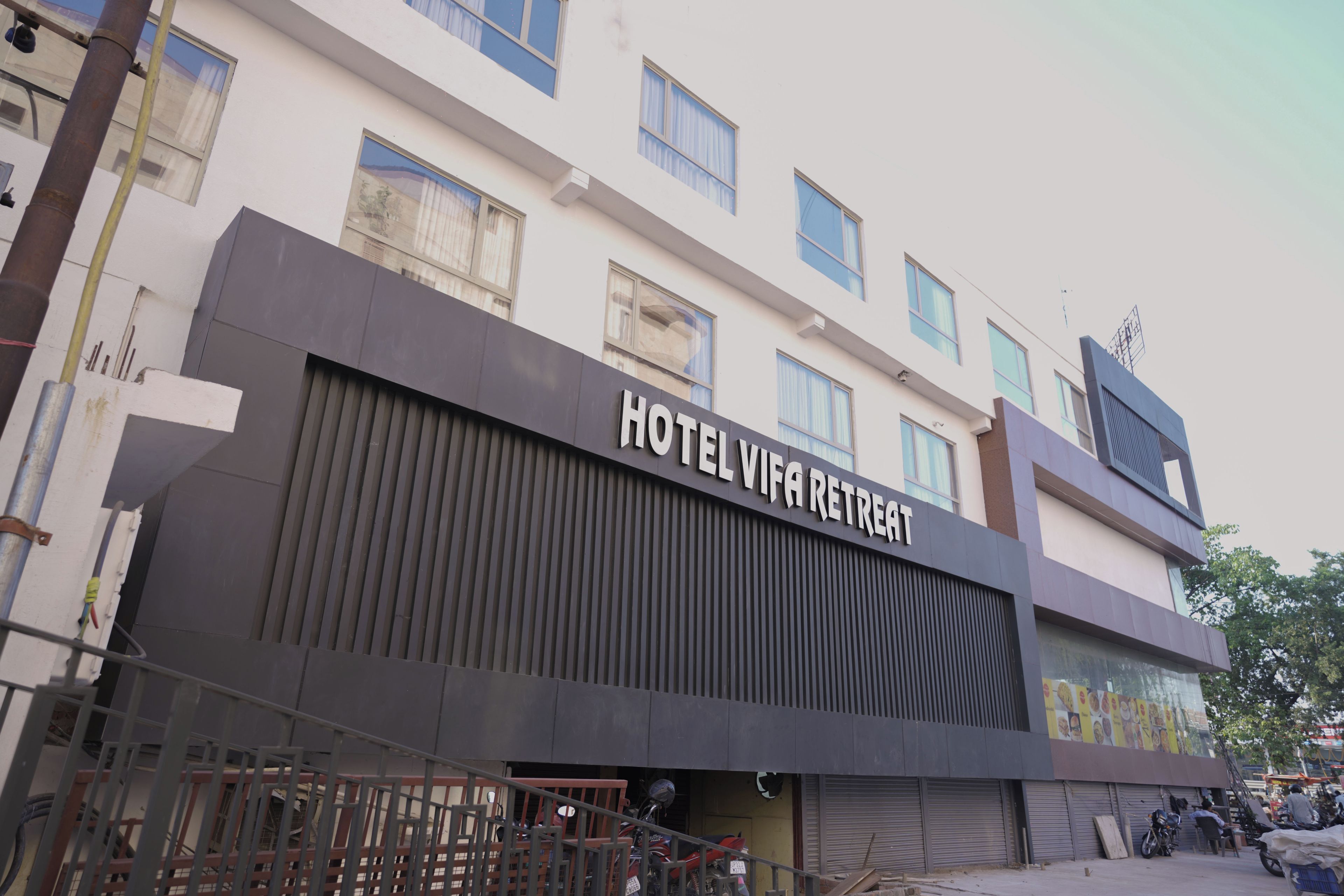 Un hotel llamado 'HOTEL VIVA RETREAT' con una fachada moderna, múltiples ventanas y una entrada visible.